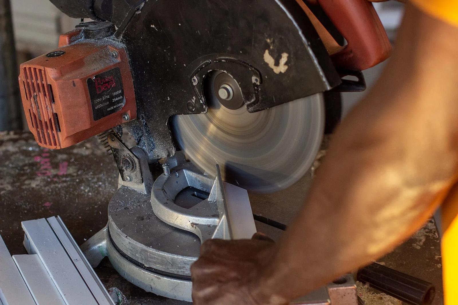 Découpe d’un profilé dans un atelier de vitrerie.